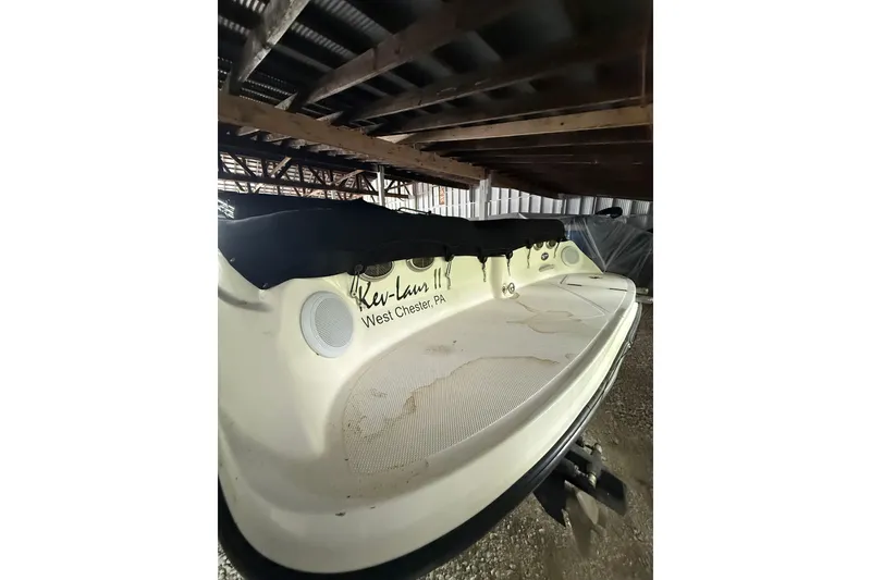 Slide: The Image of 2012 Bayliner 235 Bowrider stored under shelter, featuring covered seating area. - 11