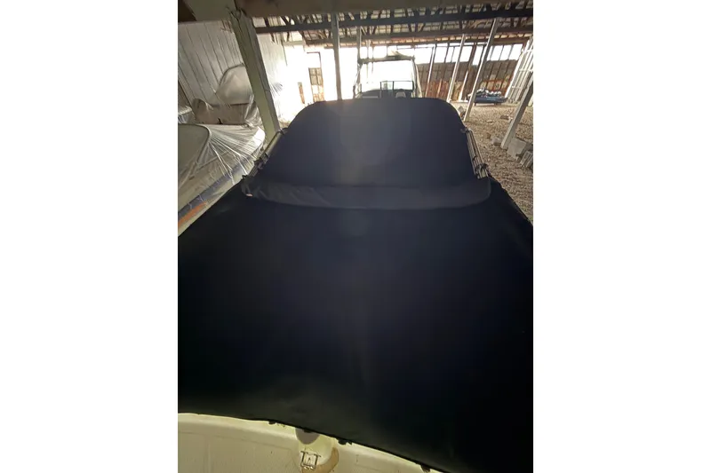 Slide: The Image of 2012 Bayliner 235 Bowrider with black cover in storage facility. - 14