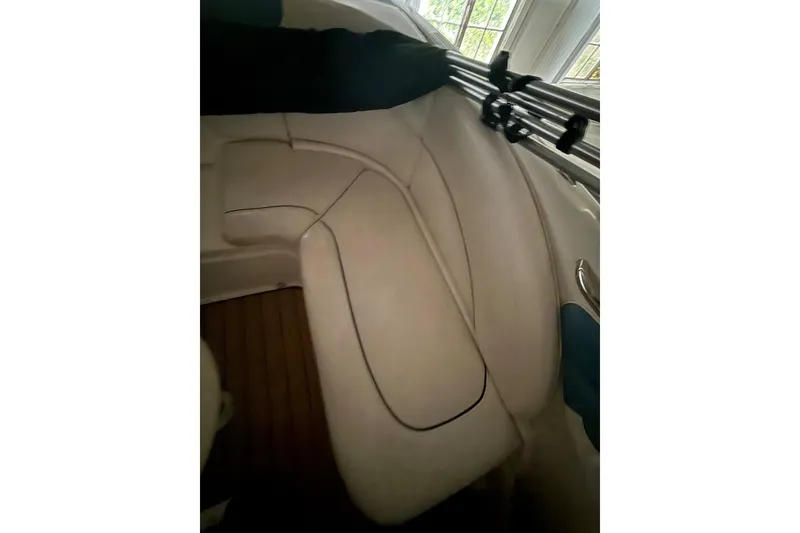 Slide: The Image of 2012 Bayliner 235 Bowrider interior with white seating and wooden flooring. - 17