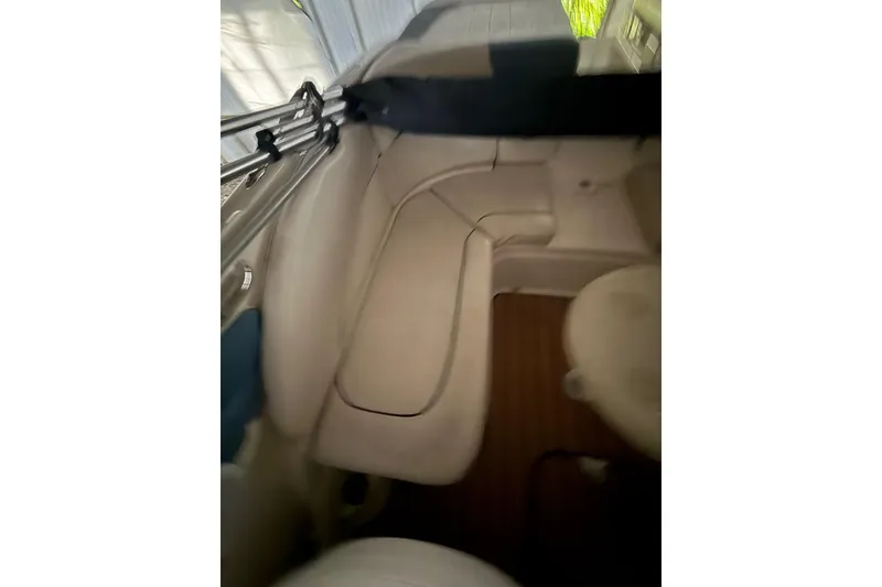 Slide: The Image of Interior of a 2012 Bayliner 235 Bowrider boat with beige seating and wood flooring. - 18