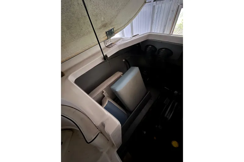 Slide: The Image of 2012 Bayliner 235 Bowrider engine compartment with open hatch and visible seating. - 23