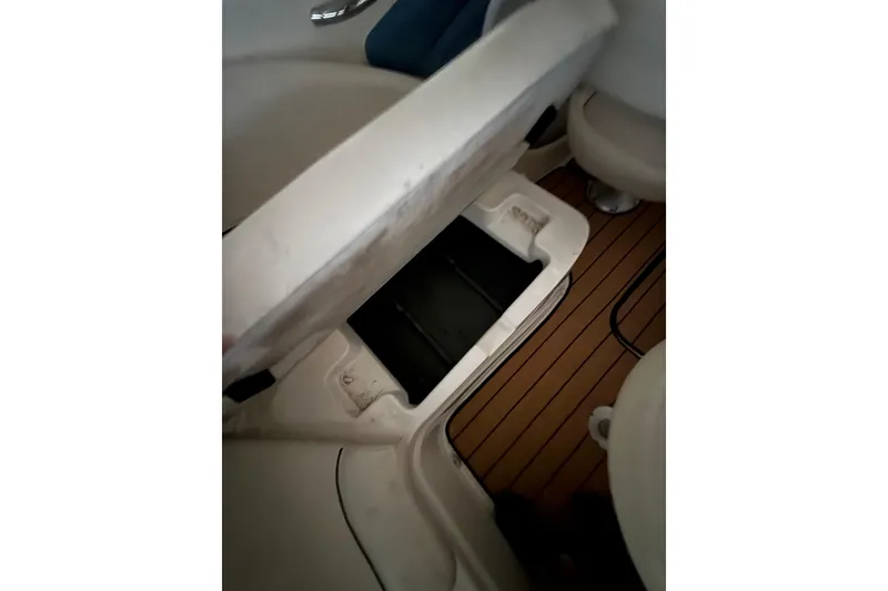 Slide: The Image of 2012 Bayliner 235 Bowrider interior storage compartment with open seat, showcasing boat design. - 26