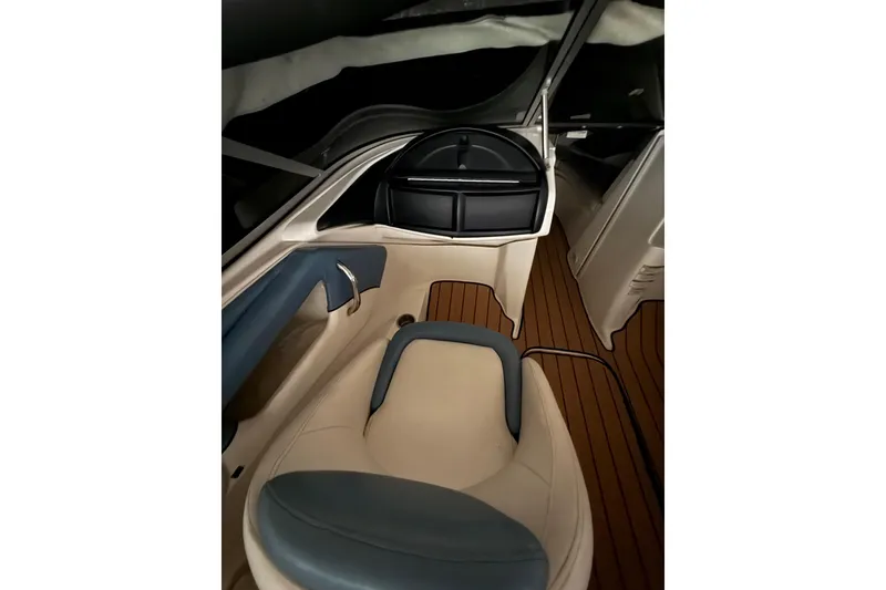 Slide: The Image of Interior of 2012 Bayliner 235 Bowrider with beige and blue seating, wood-style flooring. - 28