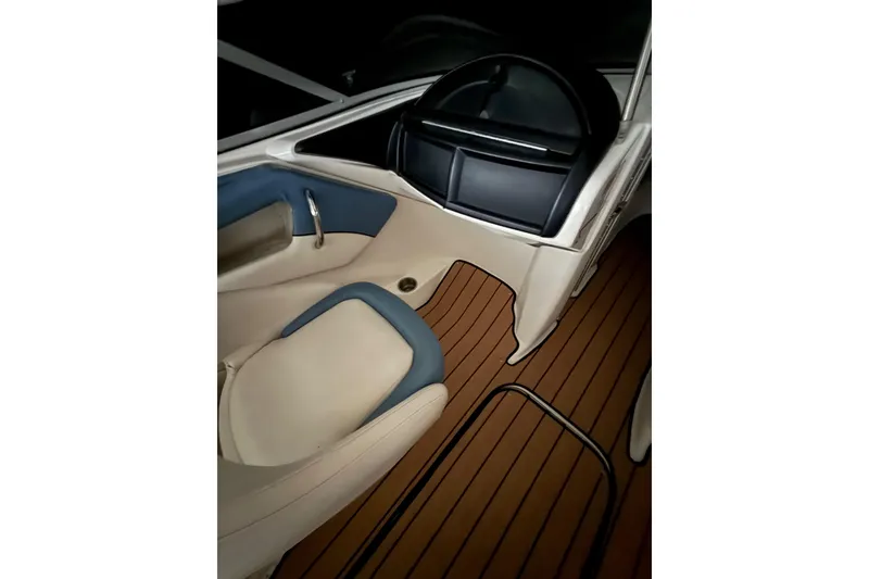 Slide: The Image of Interior of 2012 Bayliner 235 Bowrider boat with sleek seating and wood-style flooring. - 31