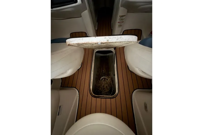 Slide: The Image of 2012 Bayliner 235 Bowrider interior with open storage compartment and rope. - 32