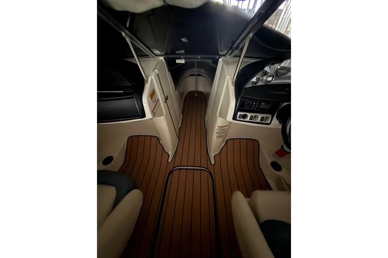 Slide: The Image of Interior view of 2012 Bayliner 235 Bowrider boat with wood-patterned flooring. - 34
