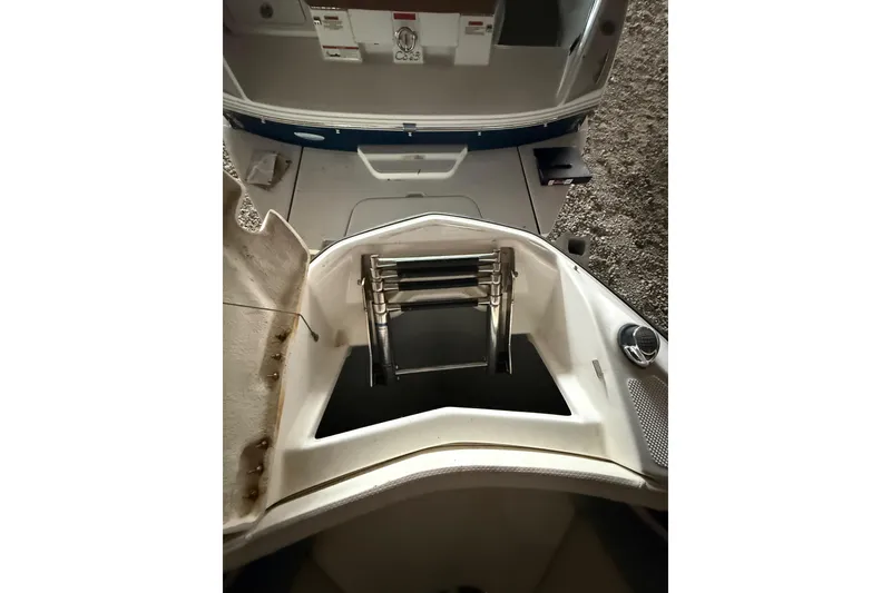 Slide: The Image of 2012 Bayliner 235 Bowrider boat interior with storage compartment and ladder. - 37