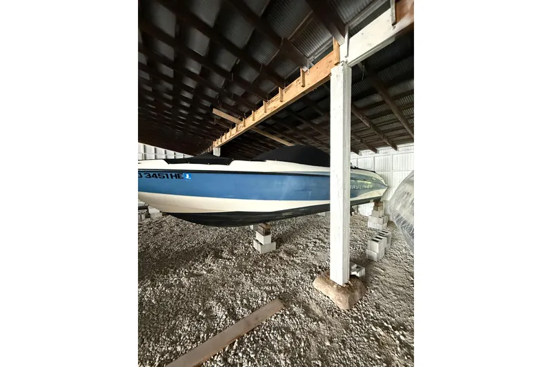 Slide: The Image of 2012 Bayliner 235 Bowrider stored in a covered area on concrete blocks. - 4