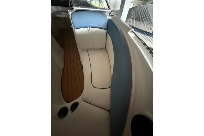Slide: The Image of Interior of a 2012 Bayliner 235 Bowrider boat with cushioned seating and wood flooring. - 40
