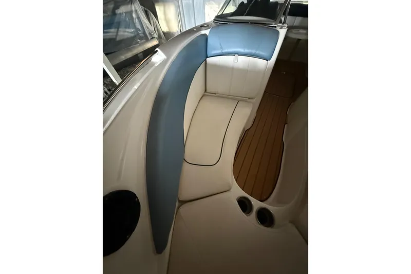 Slide: The Image of 2012 Bayliner 235 Bowrider interior with blue and white seating, wood flooring. - 41