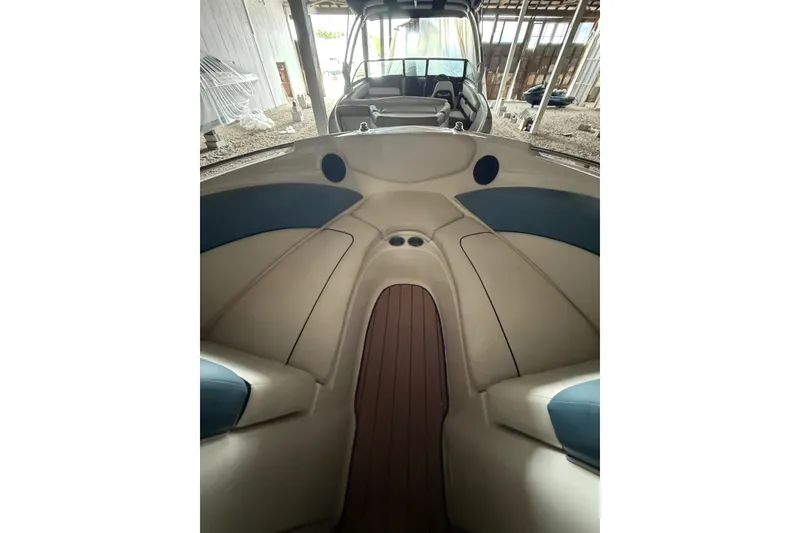 Slide: The Image of 2012 Bayliner 235 Bowrider interior with beige and blue seating, wooden flooring. - 42