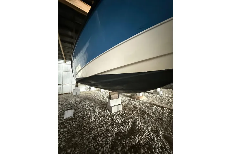 Slide: The Image of 2012 Bayliner 235 Bowrider stored on blocks in a covered area. - 6