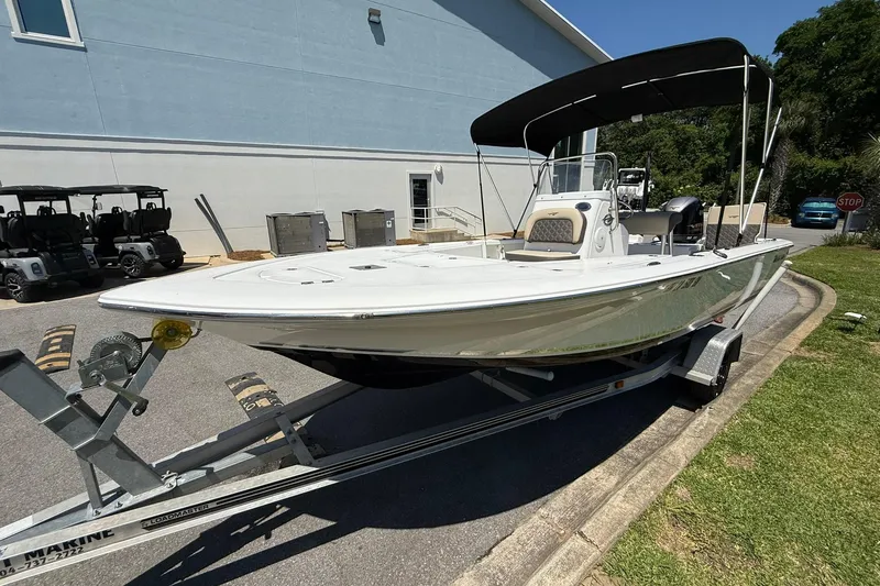 Slide: The Image of 2021 Tidewater 1910 Bay Max boat on trailer, parked outdoors near a building. - 1