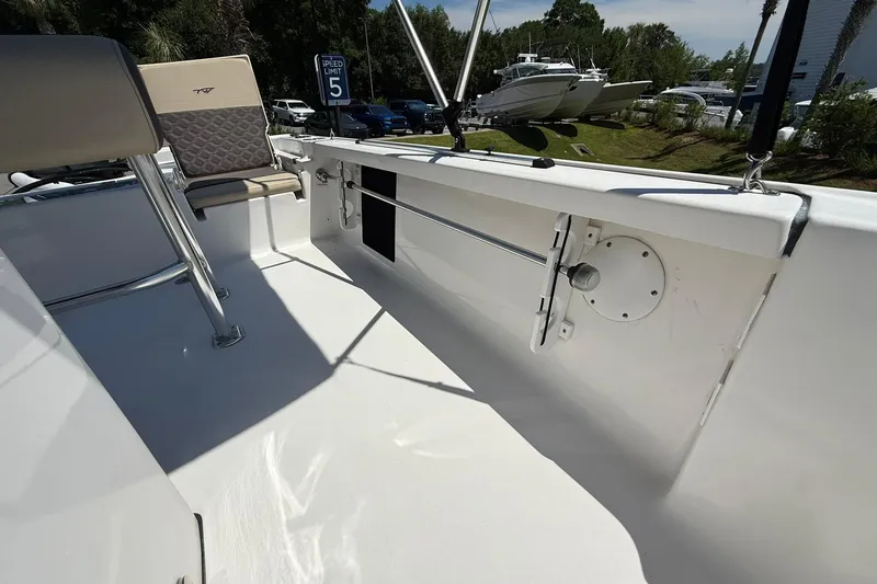 Slide: The Image of 2021 Tidewater 1910 Bay Max boat interior with seating and railing, parked outdoors. - 11