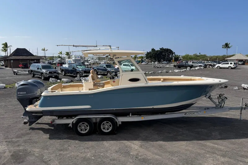 Slide: The Image of 2019 Scout 275 LXF boat on trailer in parking lot with clear sky. - 10