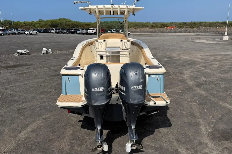 Slide: The Image of 2019 Scout 275 LXF boat with dual Yamaha 200 engines, parked on a gravel lot. - 12