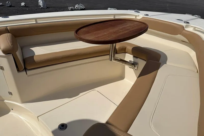 Slide: The Image of 2019 Scout 275 LXF boat interior with tan seating and a wooden table. - 16