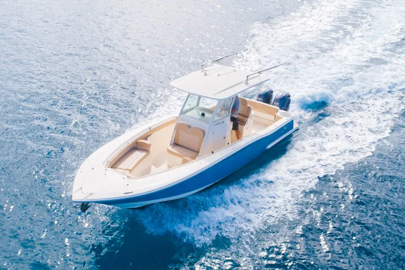 Slide: The Image of 2019 Scout 275 LXF boat cruising on open water, showcasing sleek design and powerful engines. - 2