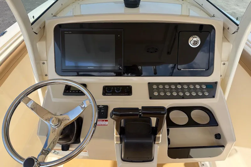 Slide: The Image of 2019 Scout 275 LXF boat dashboard with steering wheel, controls, and Garmin display. - 21
