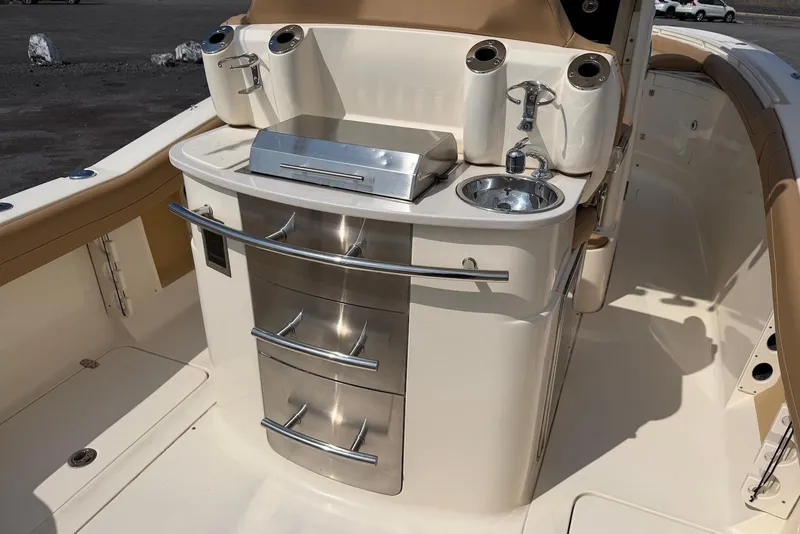 Slide: The Image of 2019 Scout 275 LXF boat interior with grill, sink, and storage drawers. - 23