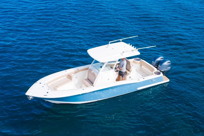 The Image of 2019 Scout 275 LXF boat on clear blue water, featuring dual outboard engines. - 3