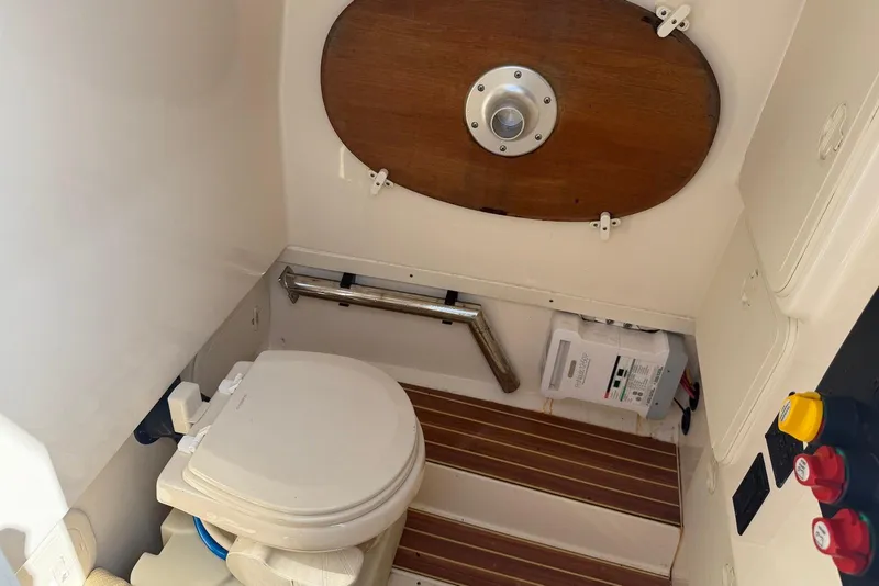 Slide: The Image of 2019 Scout 275 LXF boat interior with toilet and wooden accents. - 30