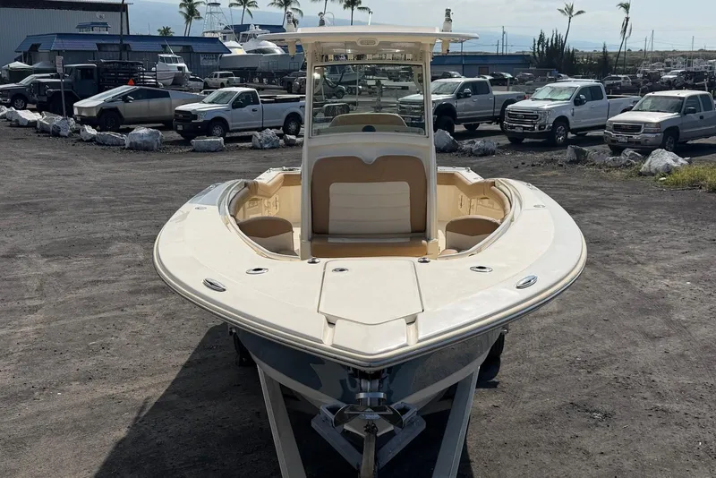 Slide: The Image of 2019 Scout 275 LXF boat on trailer in outdoor lot with trucks in background. - 8
