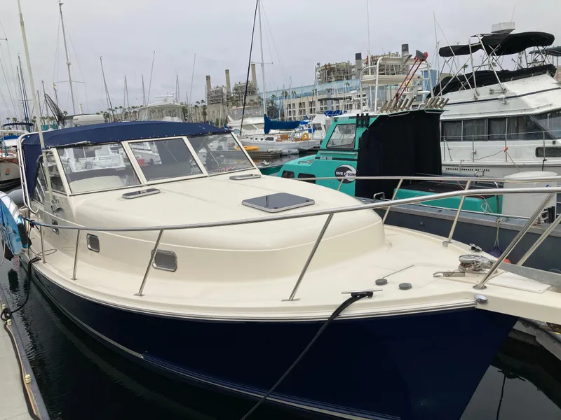 Slide: The Image of 2004 Mainship Pilot 34 docked at marina, featuring sleek design and spacious deck. - 1