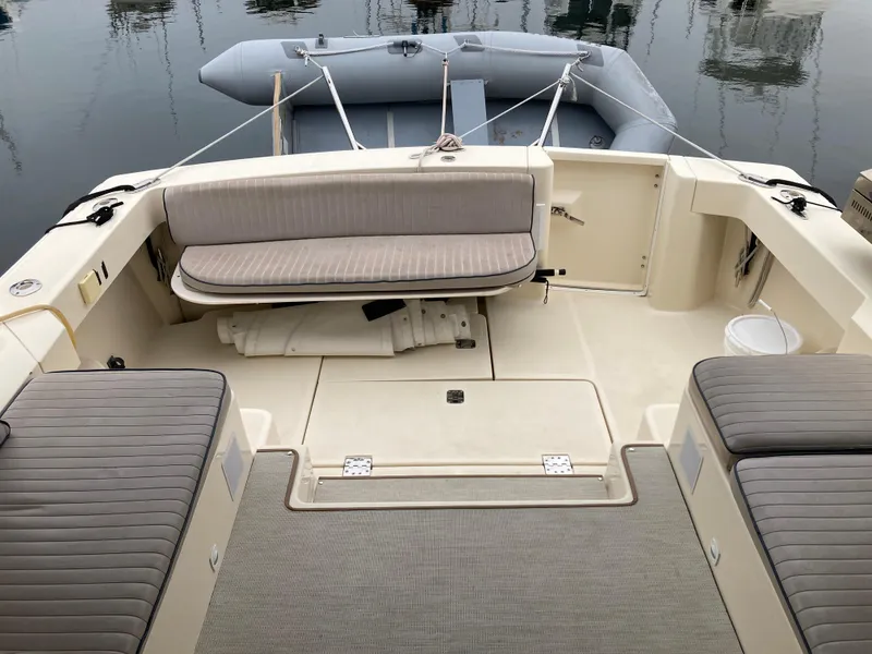 Slide: The Image of 2004 Mainship Pilot 34 boat interior with cushioned seating and inflatable dinghy. - 20