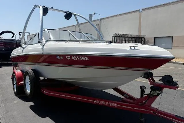 The Image of 1996 Four Winns 190 Horizon boat on trailer, parked outdoors. - 0