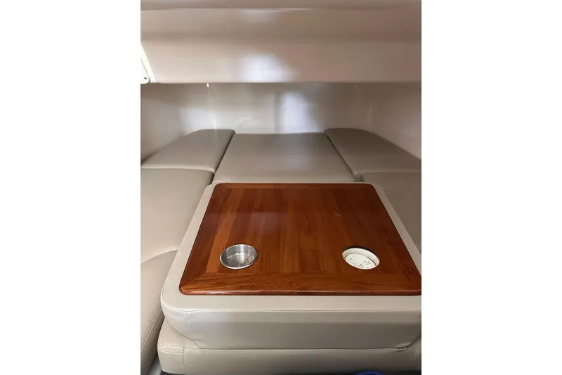 Slide: The Image of 2019 Boston Whaler 380 Outrage cabin interior with wooden table and cushioned seating. - 11