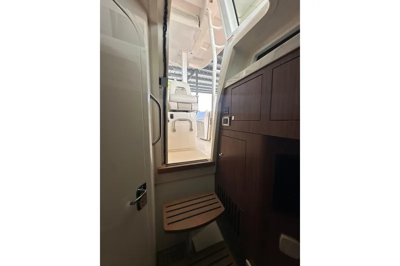Slide: The Image of Interior view of 2019 Boston Whaler 380 Outrage, showcasing cabin stairs and seating area. - 13