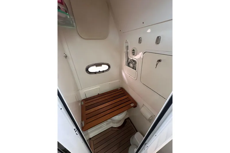 Slide: The Image of 2019 Boston Whaler 380 Outrage cabin interior with wooden accents and compact design. - 15