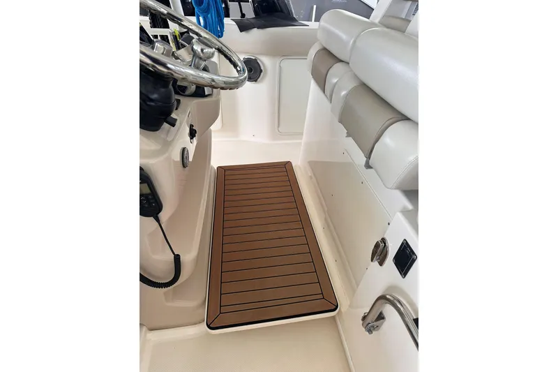 Slide: The Image of 2019 Boston Whaler 380 Outrage helm area with cushioned seating and teak-style flooring. - 17