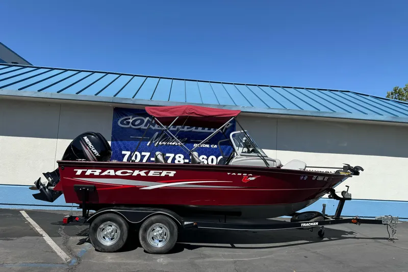 The Image of 2015 Tracker Targa V-18 Combo boat on trailer, parked outside a building. - 1