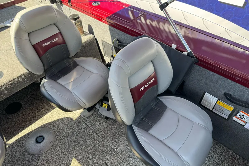 Slide: The Image of 2015 Tracker Targa V-18 Combo boat seats, gray and maroon, on textured flooring. - 19