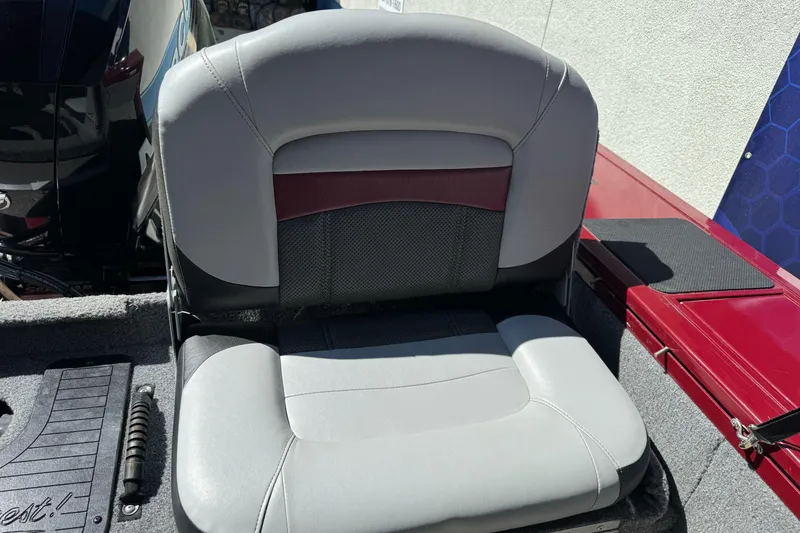 Slide: The Image of 2015 Tracker Targa V-18 Combo boat seat, gray and maroon upholstery, outdoor setting. - 22