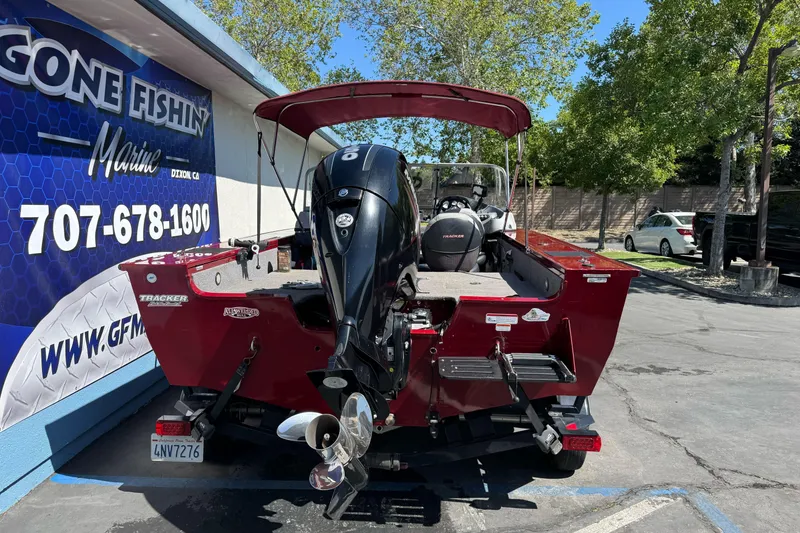 Slide: The Image of 2015 Tracker Targa V-18 Combo boat with outboard motor, parked outdoors. - 4