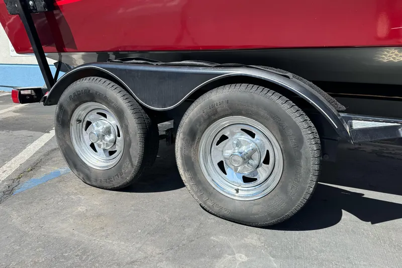 Slide: The Image of Trailer wheels of a 2015 Tracker Targa V-18 Combo boat on pavement. - 5