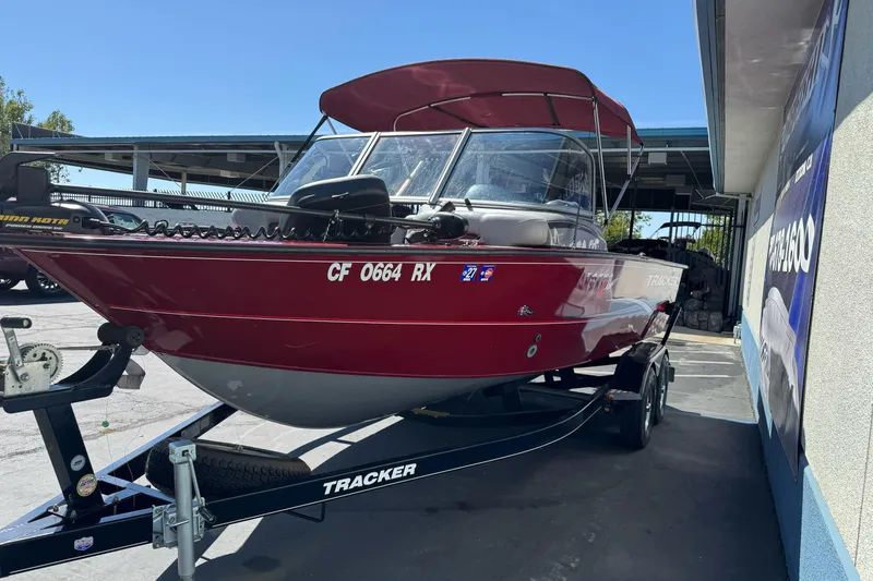 Slide: The Image of 2015 Tracker Targa V-18 Combo boat on trailer, red exterior, parked outdoors. - 8