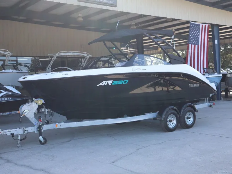 Slide: The Image of 2025 Yamaha AR220 boat on trailer in warehouse. - 2