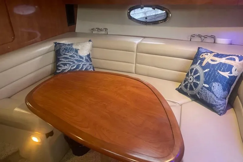 Slide: The Image of Interior of 2007 Larson Cabrio 350 with cozy seating and nautical-themed pillows. - 13