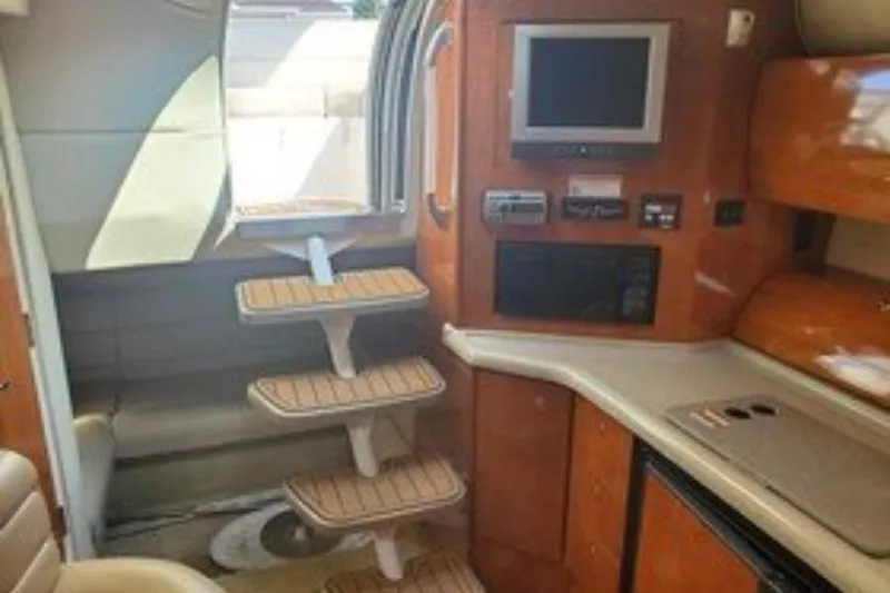 Slide: The Image of Interior of a 2007 Larson Cabrio 350 boat with wooden steps and modern amenities. - 14