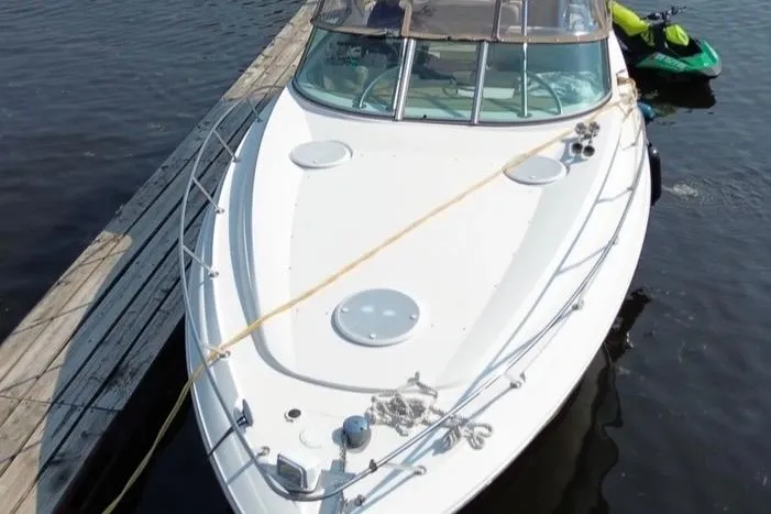 Slide: The Image of 2007 Larson Cabrio 350 boat docked on calm water with a jet ski nearby. - 5