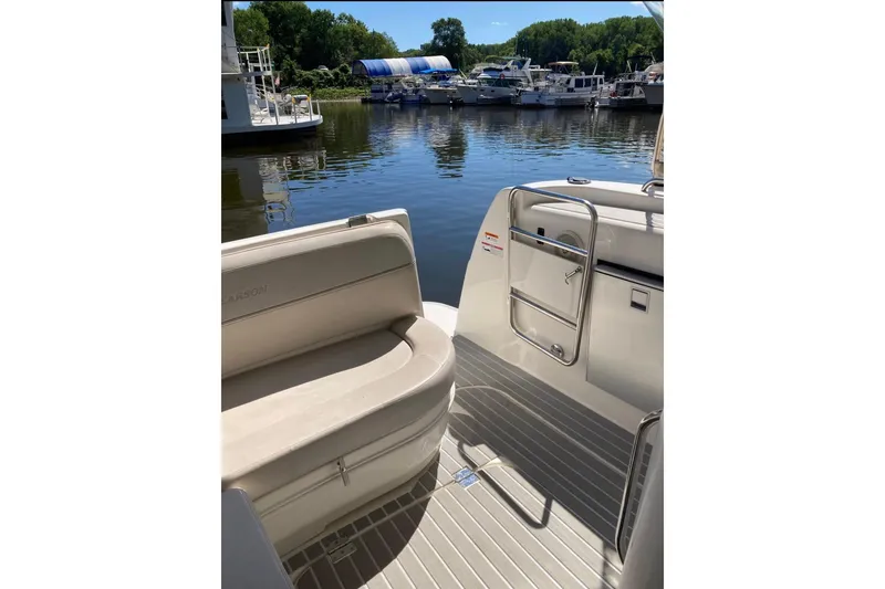 Slide: The Image of 2007 Larson Cabrio 350 boat interior with seating, docked at a marina. - 8