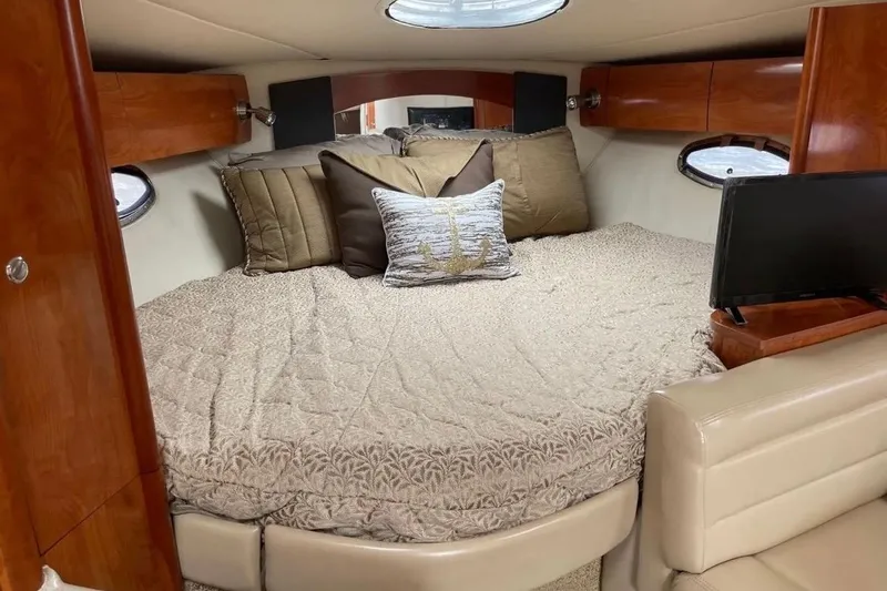 Slide: The Image of Luxurious cabin interior of 2007 Larson Cabrio 350 with cozy bedding and elegant wood finishes. - 9