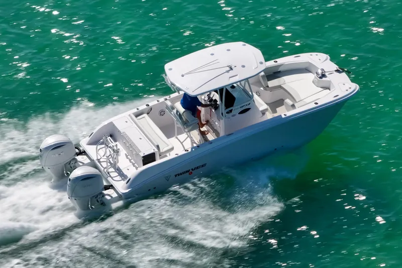 Slide: The Image of 2026 Twin Vee 240 GFX CC boat cruising on clear turquoise water. - 10