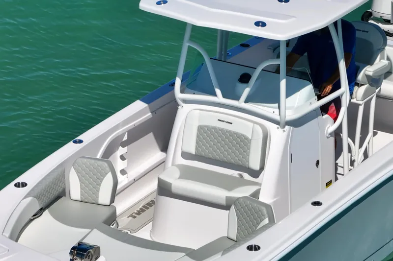 Slide: The Image of 2026 Twin Vee 240 GFX CC boat with sleek design and comfortable seating on turquoise water. - 12