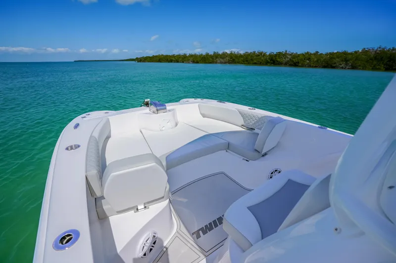 Slide: The Image of 2026 Twin Vee 240 GFX CC boat interior with plush seating on turquoise water. - 22