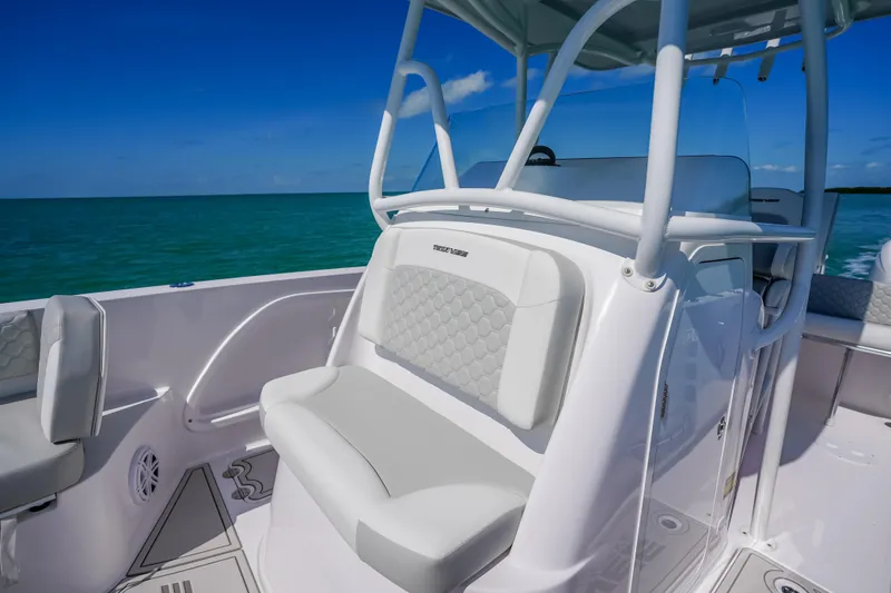 Slide: The Image of 2026 Twin Vee 240 GFX CC boat interior with cushioned seating, ocean backdrop. - 28